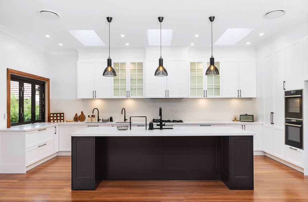 Large custom kitchen with stone benchtops and integrated storage solutions