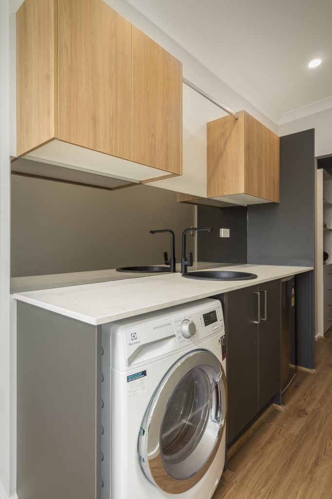 Integrated wardrobe and laundry with custom joinery in parents retreat