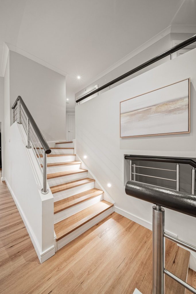 Painted stair risers with timber treads and stair lighting elevates any staircase