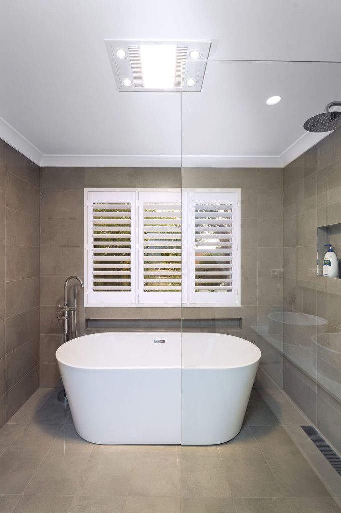 Renovated bathroom featuring a wall-hung vanity and premium fixtures and freestanding bath