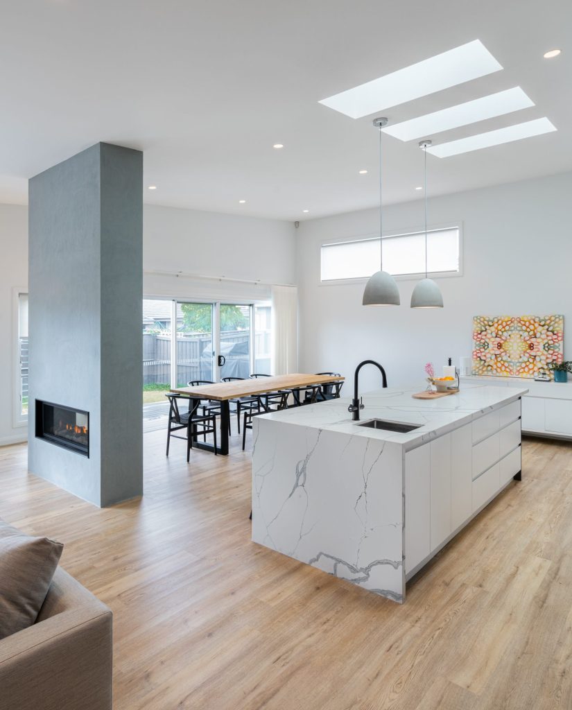Stone kitchen island with waterfall edge and pendant lighting