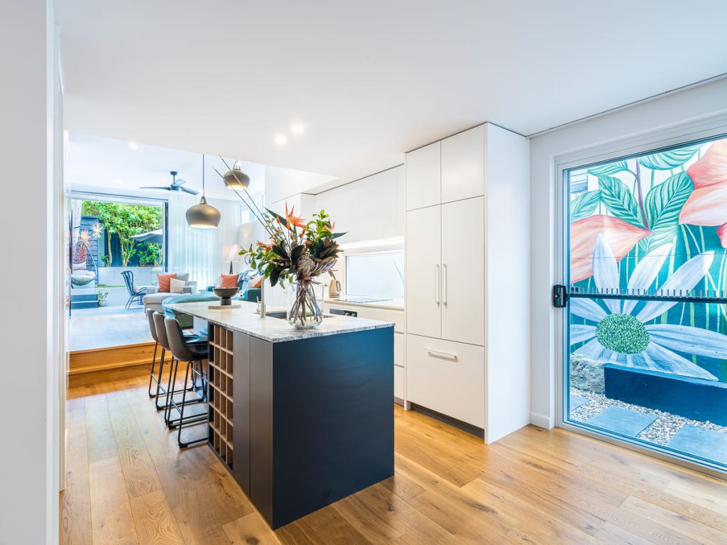 Large custom kitchen with stone benchtops and integrated storage solutions