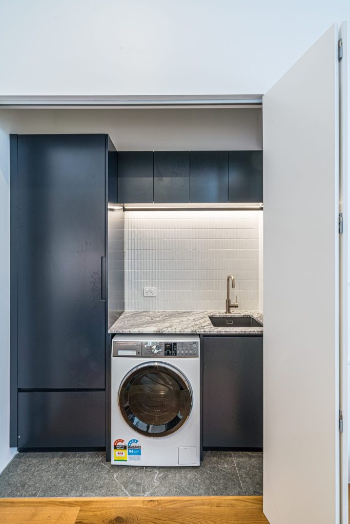 Bifold doors concealing the laundry custom joinery in Balmain