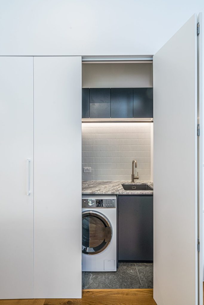 Bifold doors concealing the laundry custom joinery in Balmain